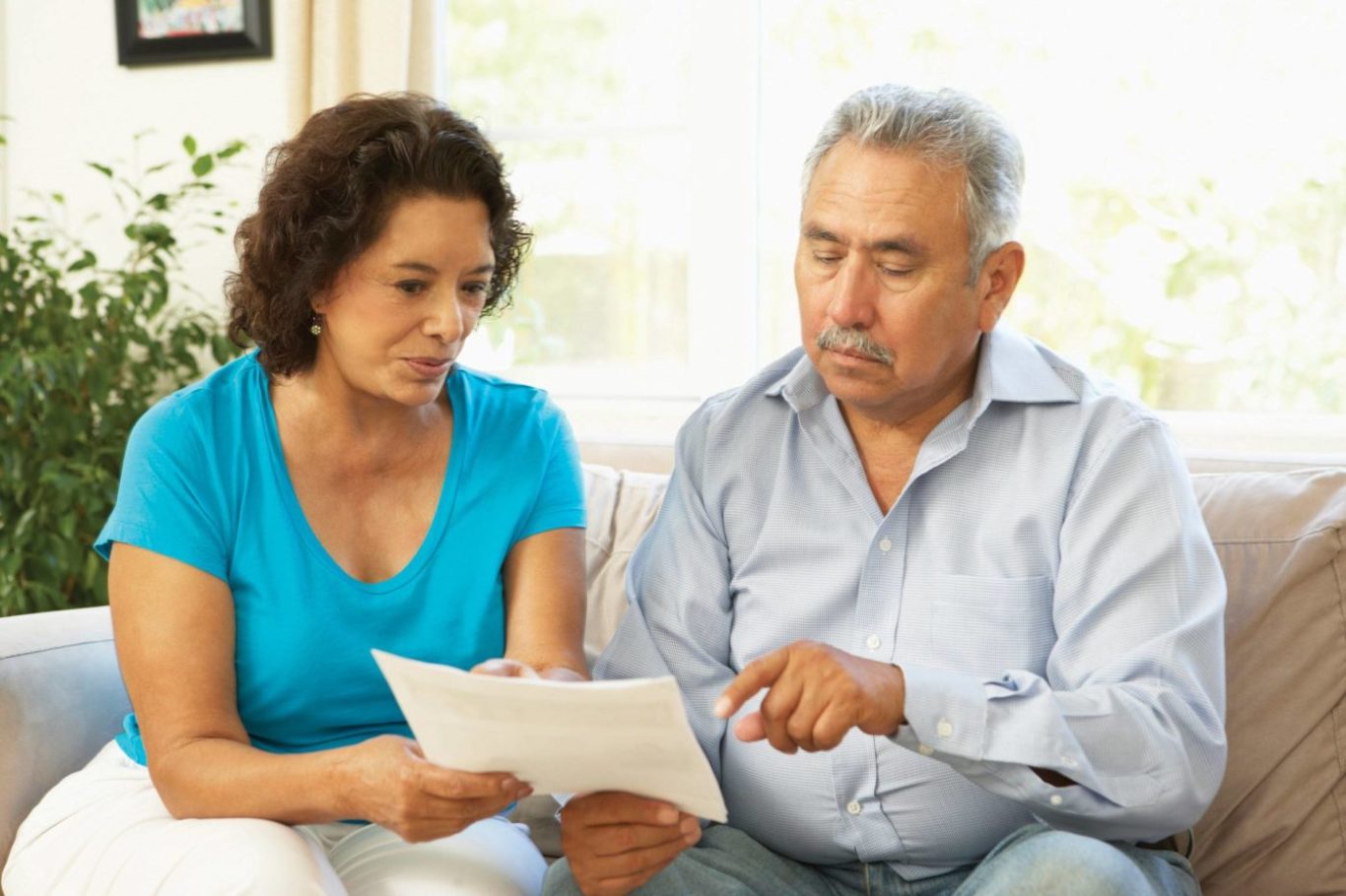 Elderly couple examining document, reviewing caregiver support and resources