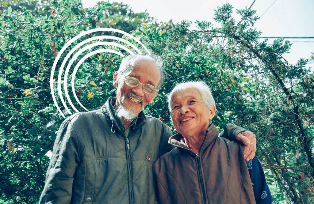 Asian-American couple smiling with the California Caregiver Resource Centers logo overlaid