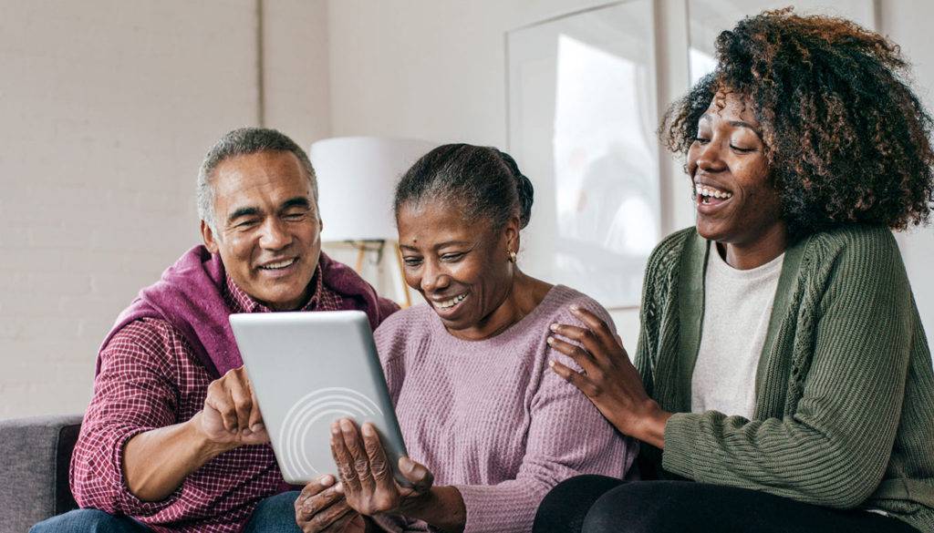 African-American family using tablet with CRC logo exploring online caregiver training and resources