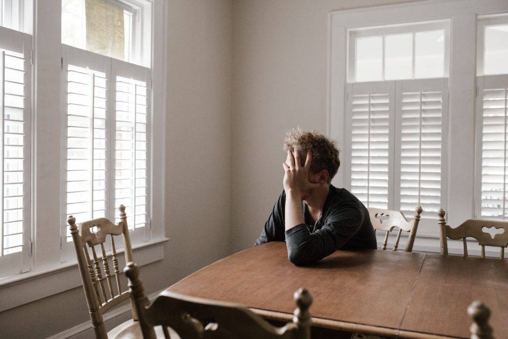 Man at table with head in hands