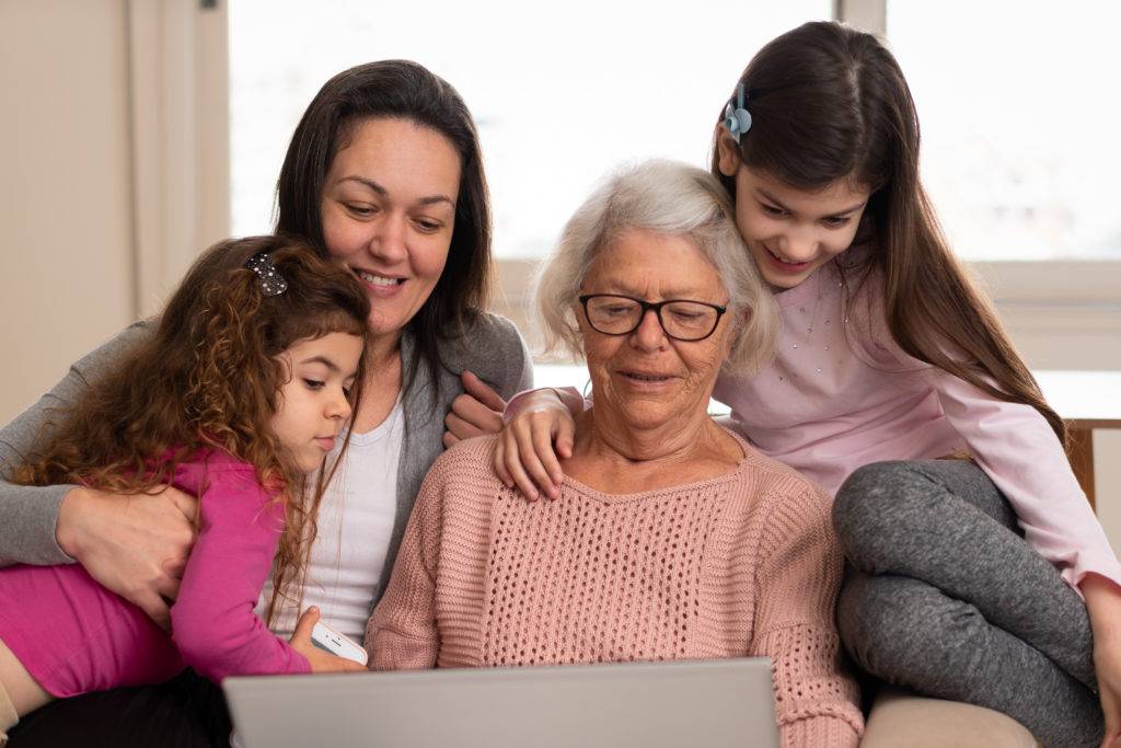 Happy cheerful female multigenerational family with laptop