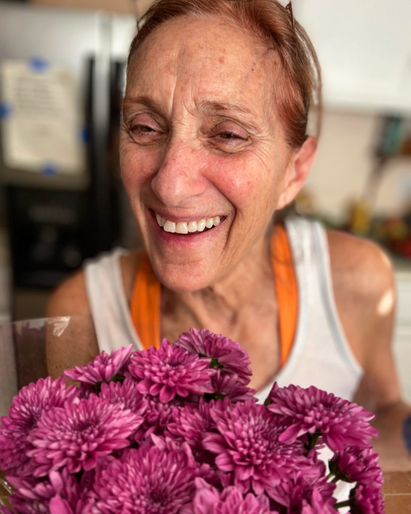 woman smiling and holding flowers