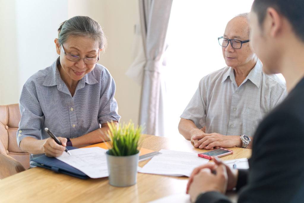 senior couple reviewing documents in their home at a table