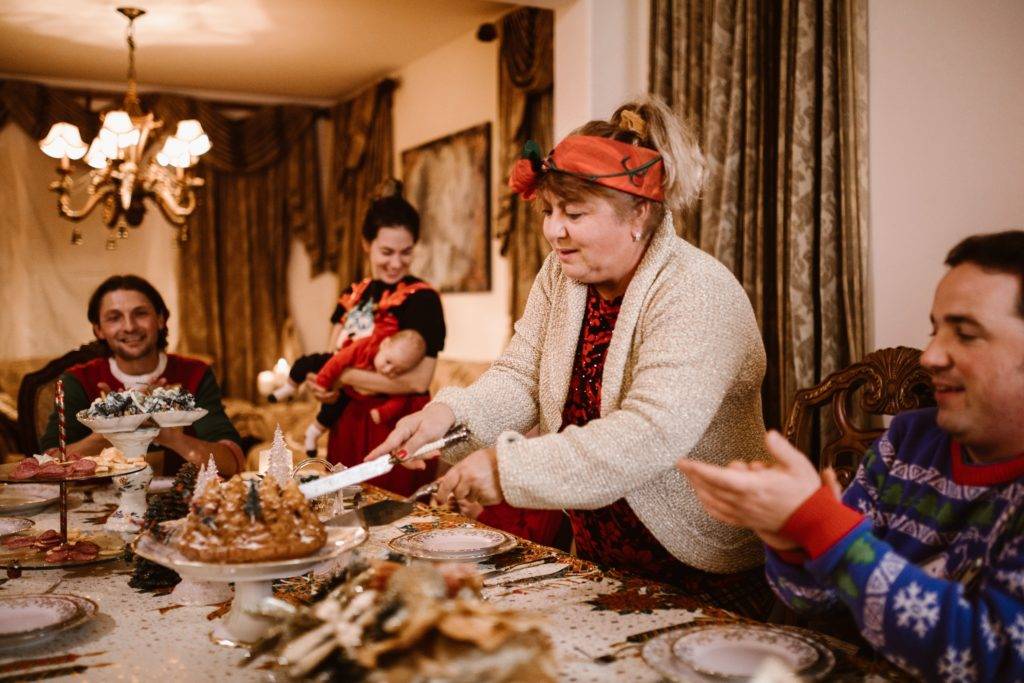 Adult woman cutting cake for family gathering at holiday