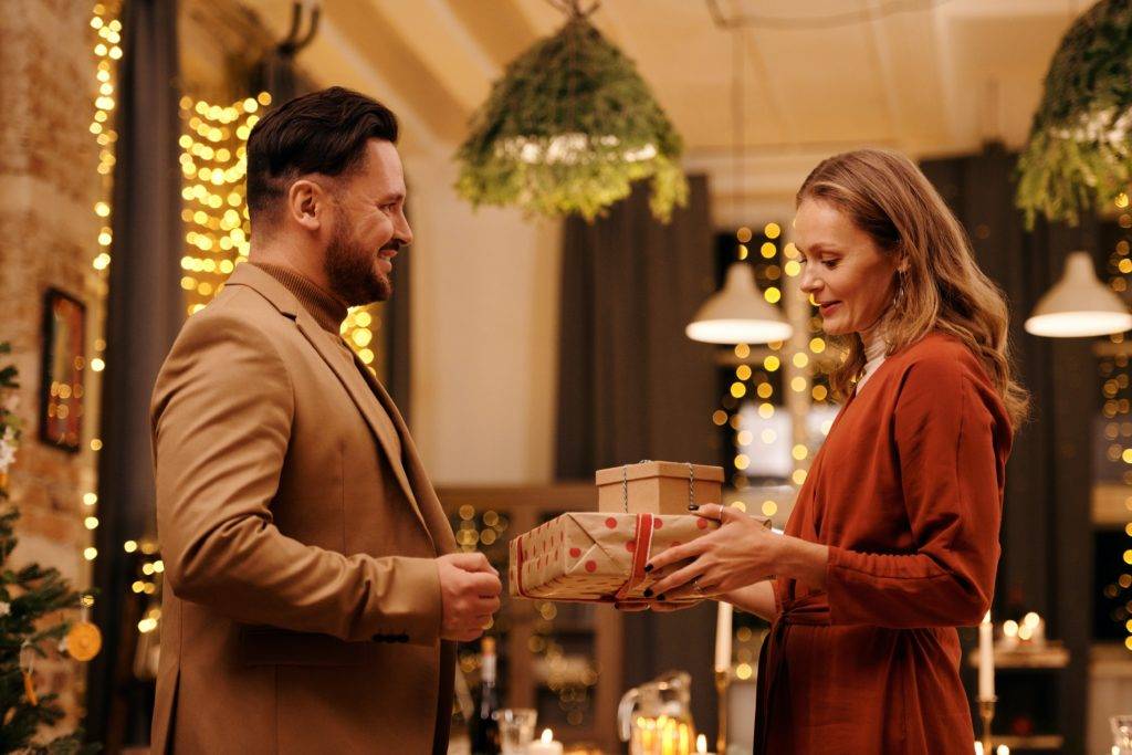 Adult couple exchanging gifts at holiday