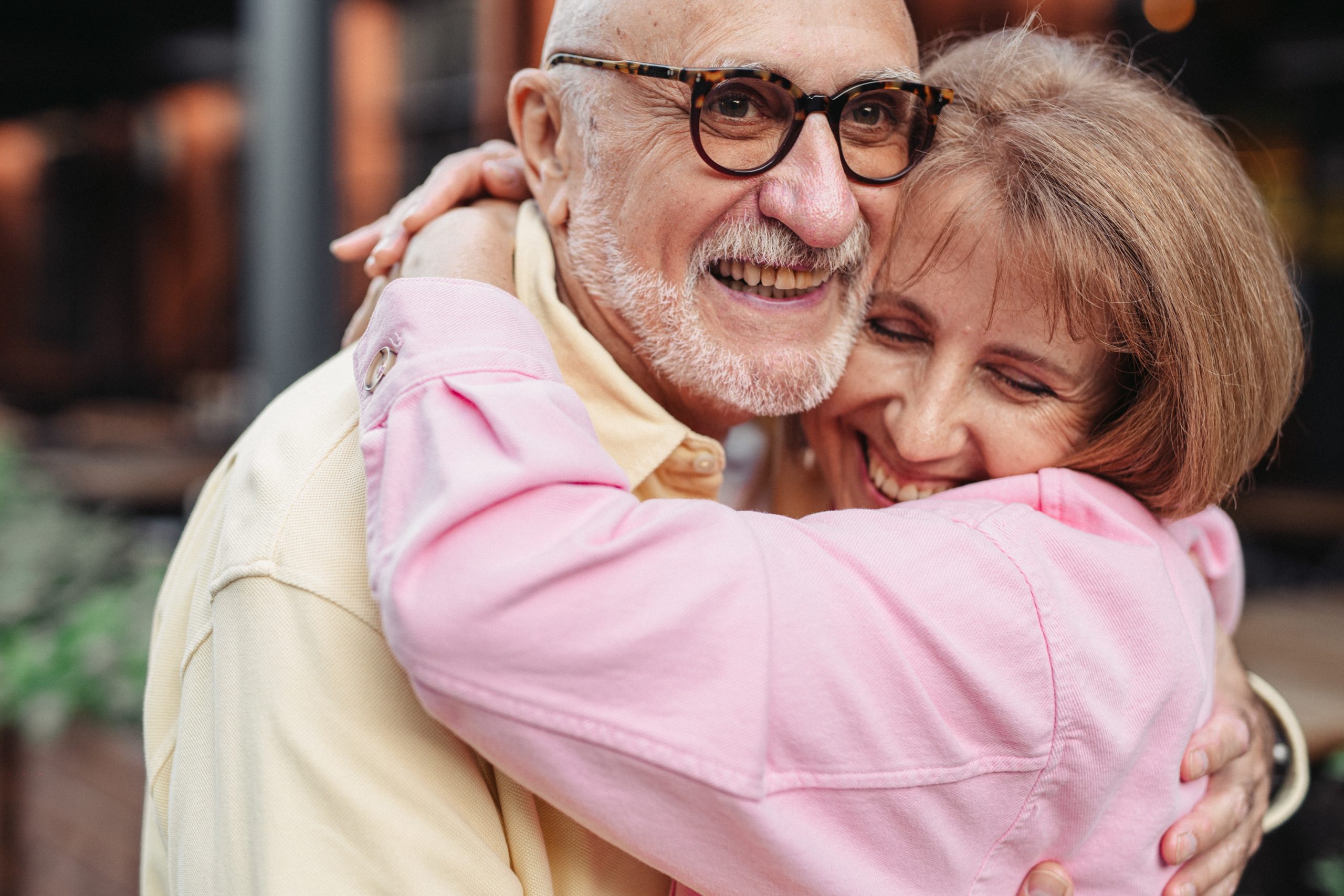 Elderly couple hugging and smiling