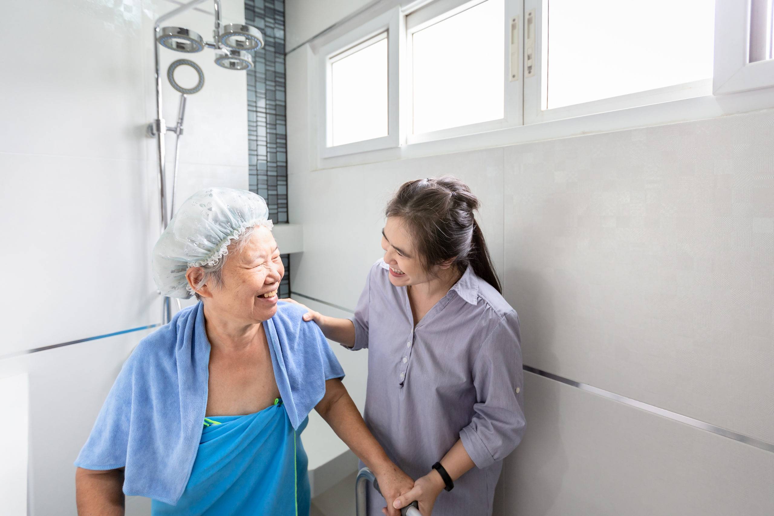 Asian daughter helps elderly mother out of shower