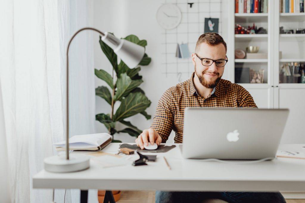 Man sits at computer smiling