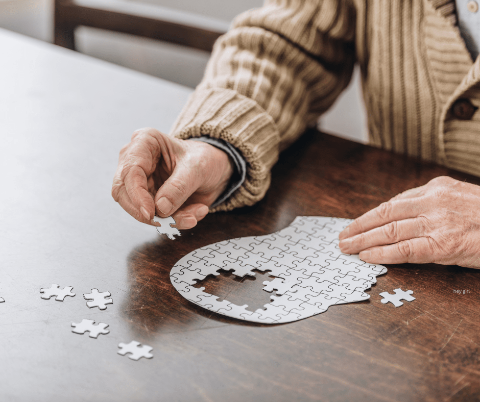 image shows an individual putting together a puzzle of the outline of a human face