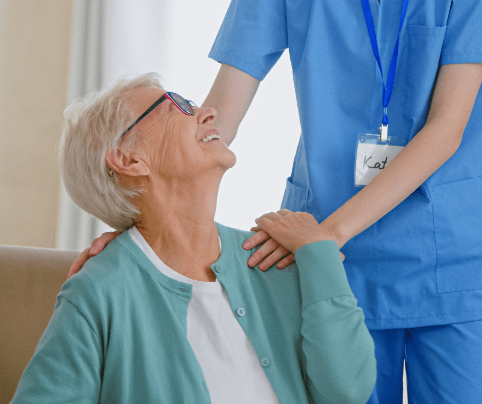 An older woman gazing upwards at her caregiver that is in scrubs