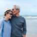 Elderly couple on beach, man kissing woman on forehead